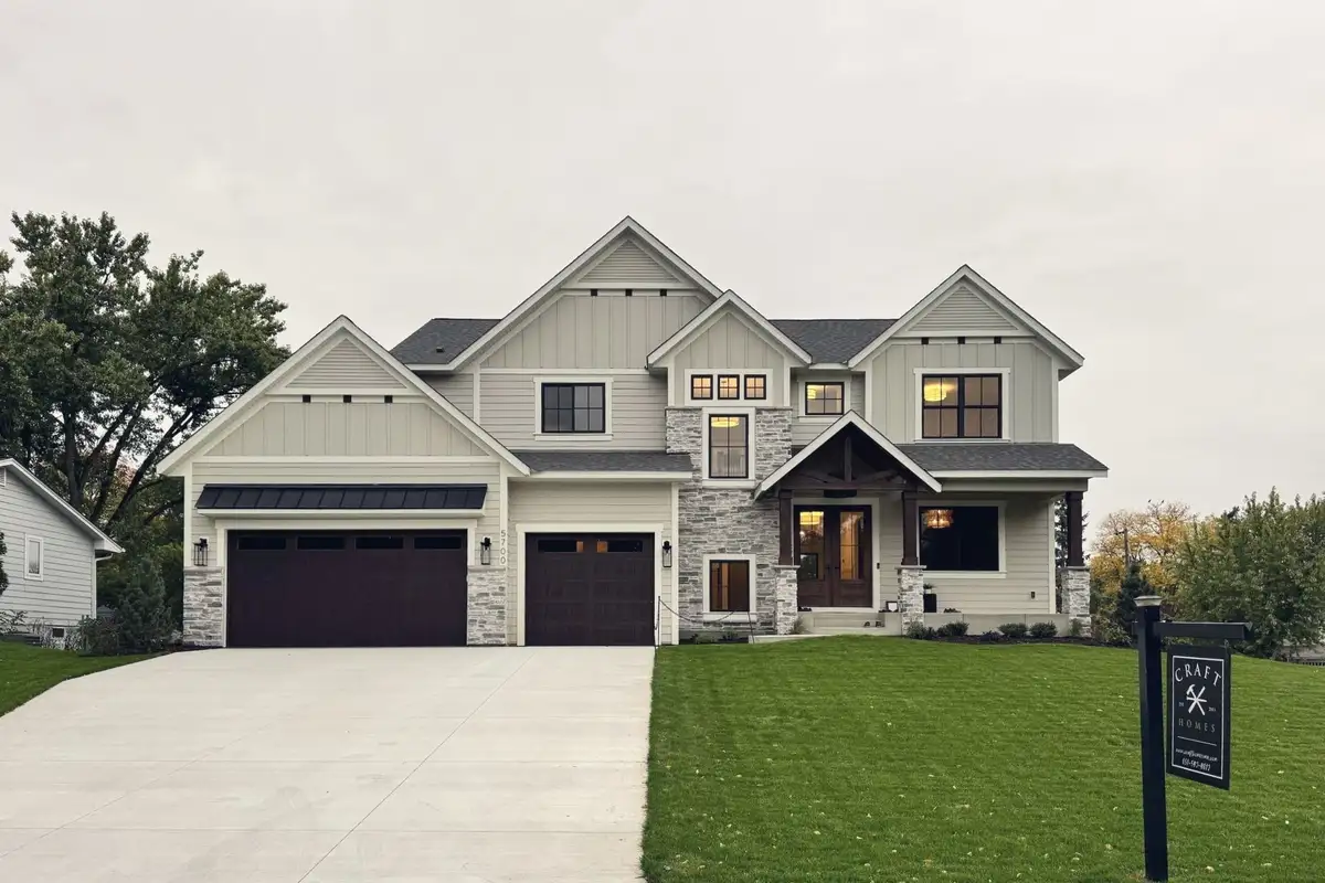 The Craft Homes model in Edina from the street, with its builder sign on the lawn