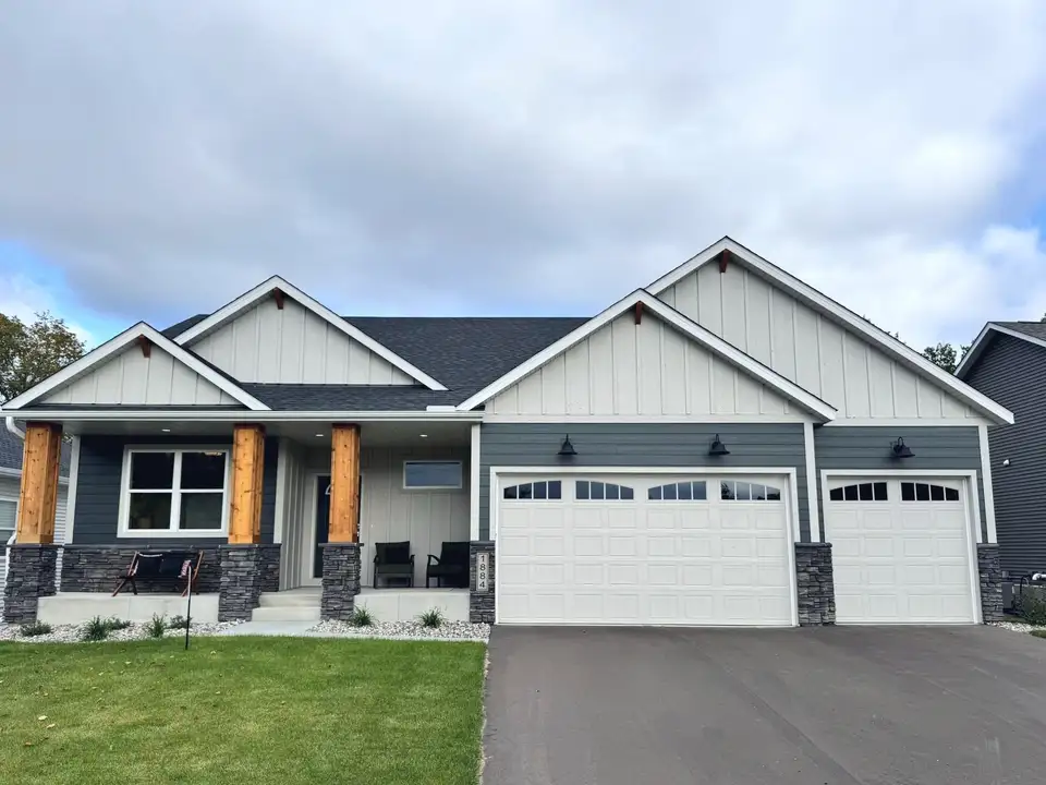 A craftsman-style rambler with cedar porch posts and a three-car garage