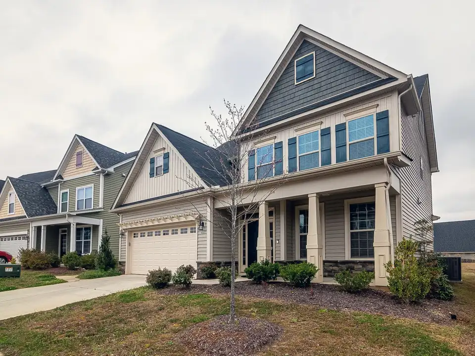 A new two-storey home with a front porch in a young neighbourhood