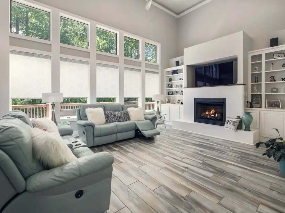 A two-storey great room with a wall of windows onto the woods